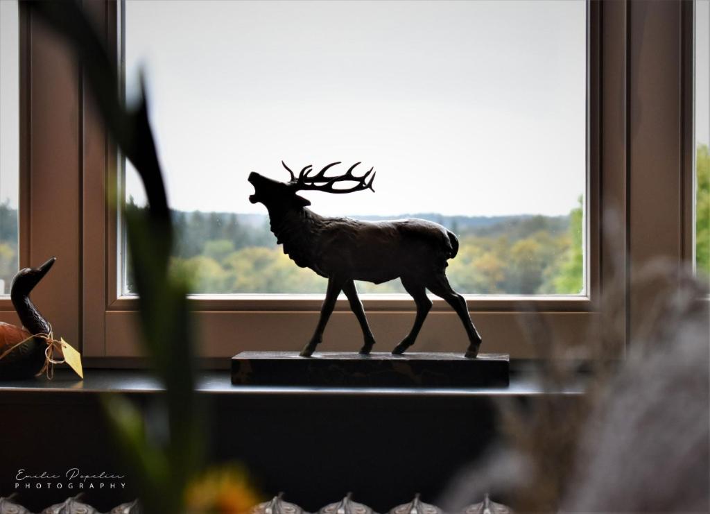 Statuette de cerf en bronze devant la forêt